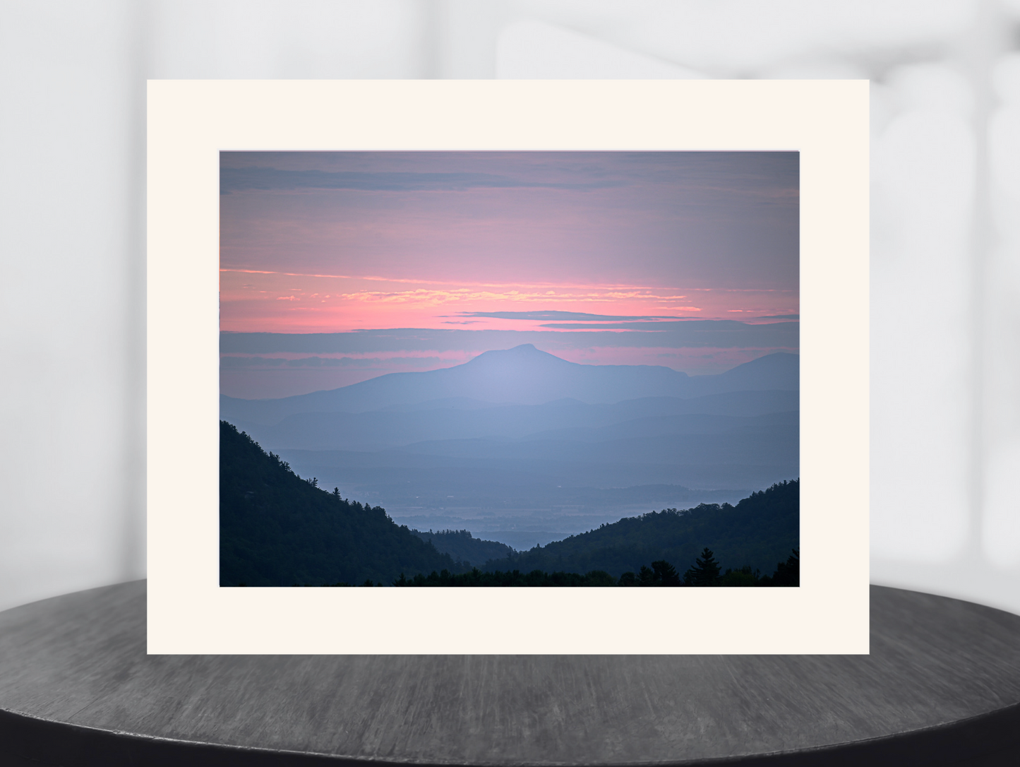 print of a hazy sunrise over the Champlain valley and camels hump mountain from the Adirondack Mountains