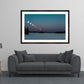 Framed artwork of a lunar eclipse over a body of water in a living room setting.