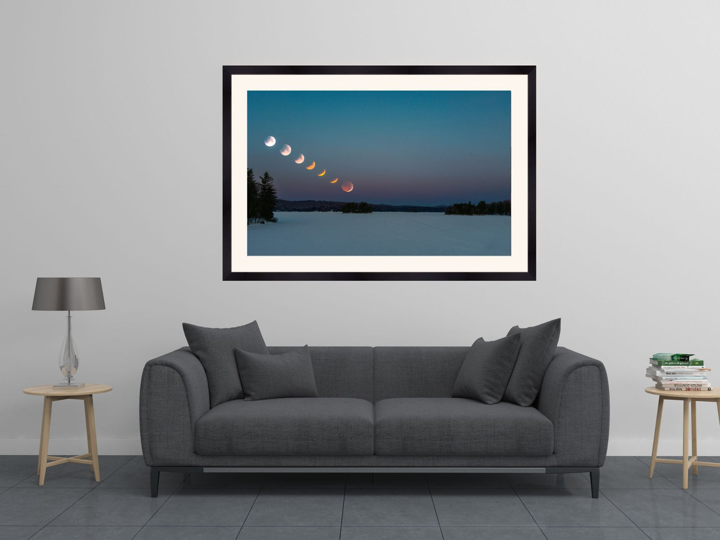 Framed artwork of a lunar eclipse over a body of water in a living room setting.