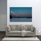 Gray sofa with decorative pillows in a living room setting, featuring a wall art of a lunar eclipse.