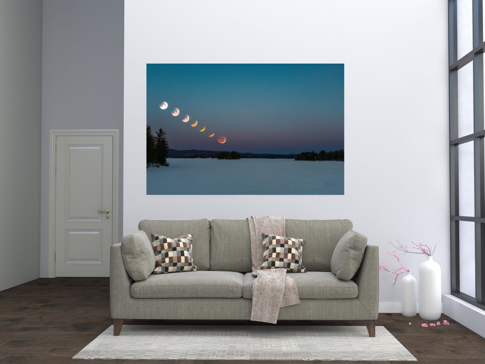 Gray sofa with decorative pillows in a living room setting, featuring a wall art of a lunar eclipse.