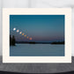Framed photograph of a lunar eclipse sequence over a snowy landscape.