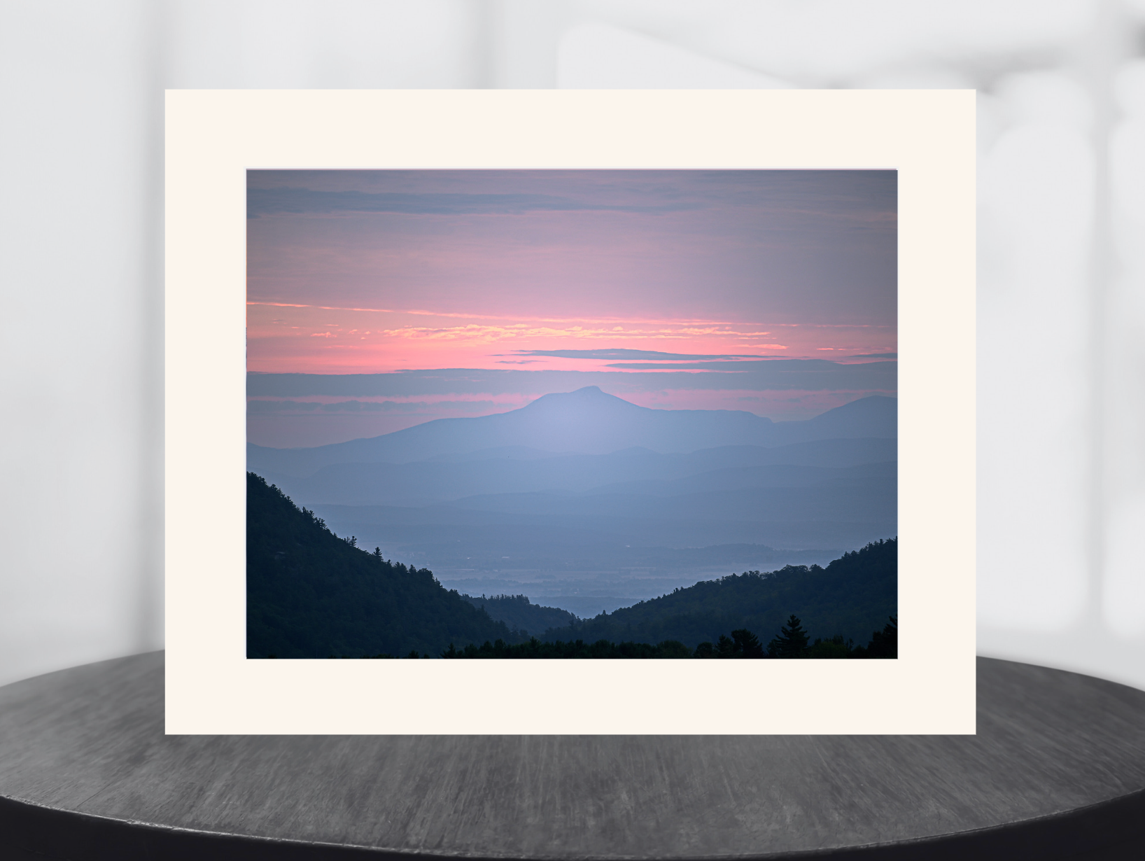 print of a hazy sunrise over the Champlain valley and camels hump mountain from the Adirondack Mountains 
