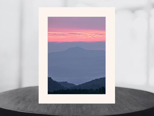 print of a hazy sunrise over the Champlain valley and camels hump mountain from the Adirondack Mountains
