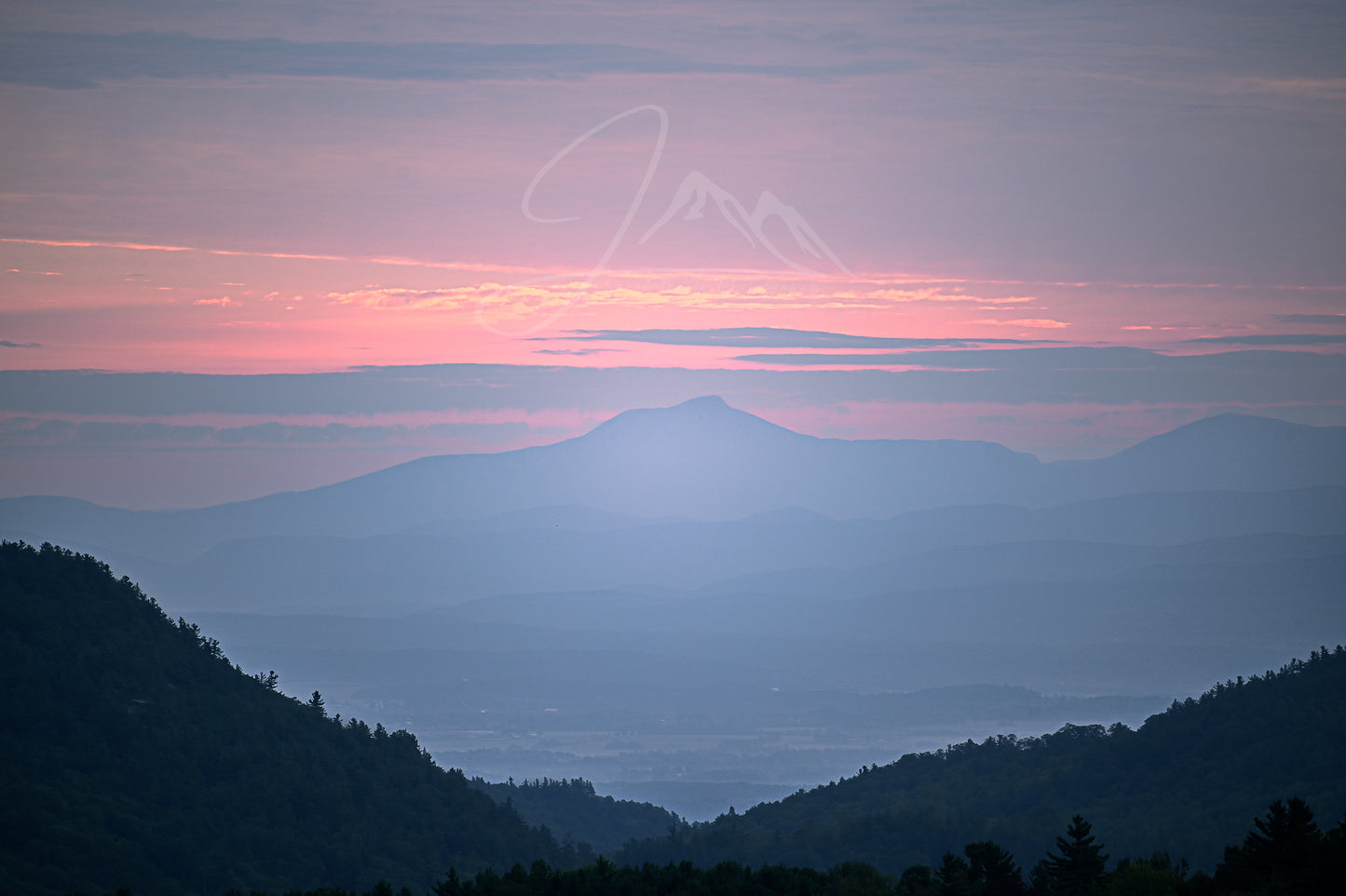 print of a hazy sunrise over the Champlain valley and camels hump mountain from the Adirondack Mountains 
